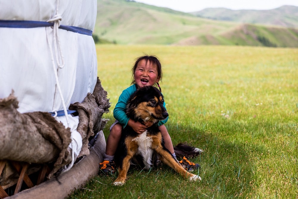 Reisereportage Mongolei mongolischer junge mit hund vor jurte