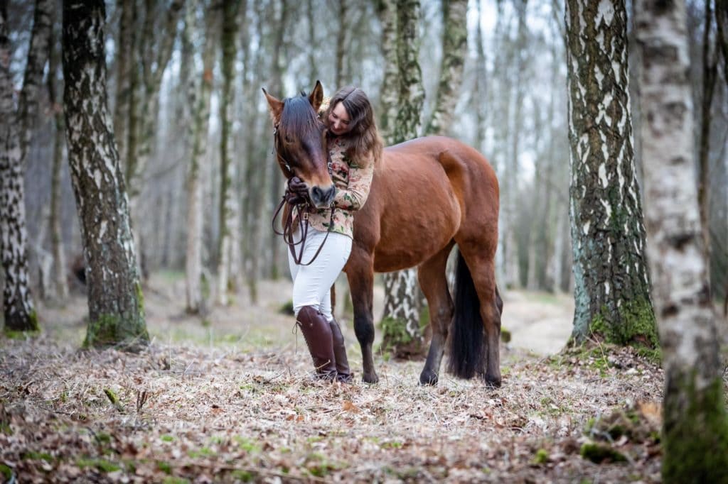 Frau mit Pferd im Birkenwald