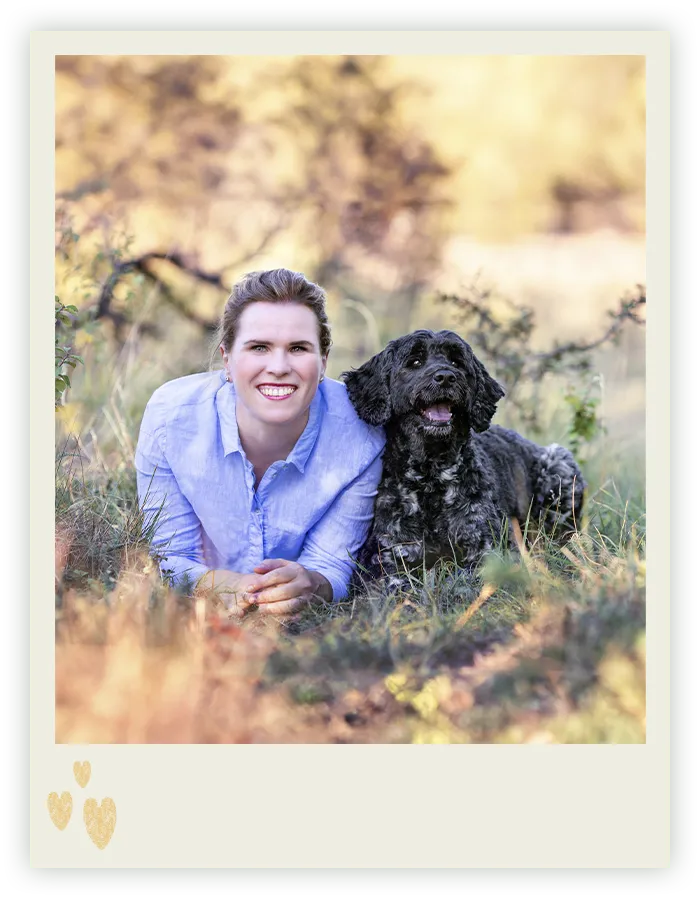 Tierfotografin Ines Arnshoff aus Bremen lächelt in die Kamera, dicht neben ihr ihr schwarzer Portugiesischer Wasserhund Winnie.