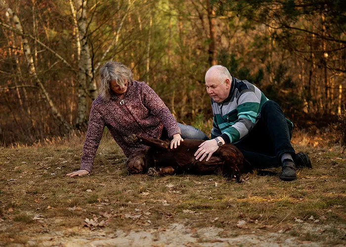 Luna liegt entspannt auf dem Rücken, während Silke und Thomas sie kraulen, stressfreies Fotoshooting mit einem alten Hund.