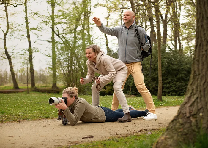 Tierfotografin Ines Arnshoff fotografiert am Boden liegend, während die Kund*innen mithelfen, die Aufmerksamkeit des Hundes zu wecken, Behind the Scenes aus Bremen.