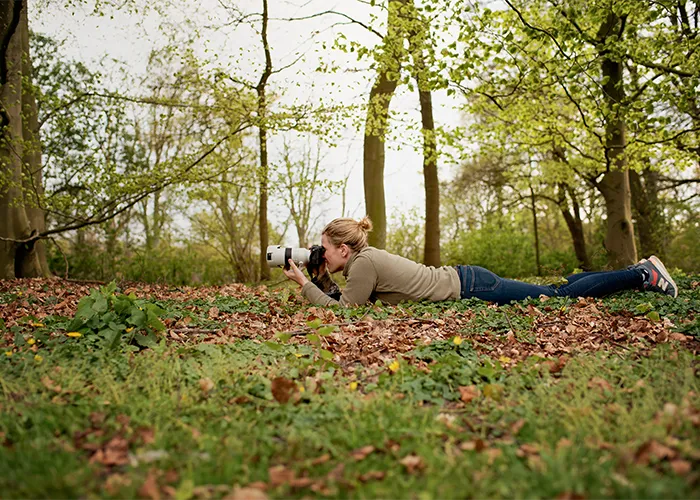 Tierfotografin Ines Arnshoff fotografiert dicht am Boden liegend im Park, ein Blick hinter die Kulissen aus Bremen.