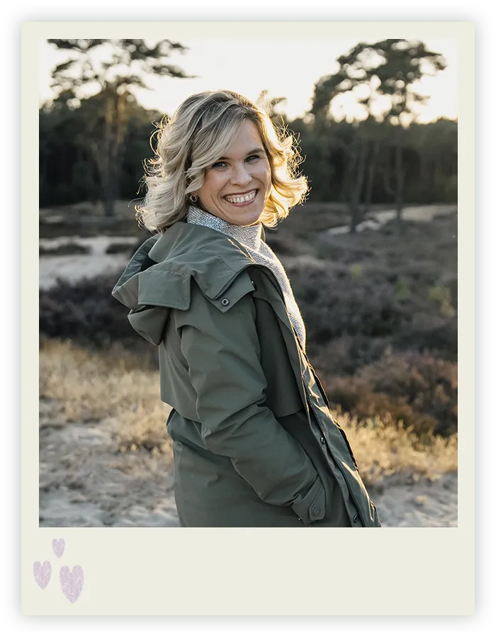 Ines Arnshoff blickt lachend über die Schulter, hinter ihr die abendliche Heidelandschaft